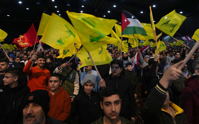 Supporters of the Iranian-backed Hezbollah group wave Hezbollah and Palestinian flags, as they attend a ceremony to mark the fourth anniversary of the assassination of Iran's Quds force General Qassem Soleimani, January 3, 2024. (AP Photo/Hassan Ammar)