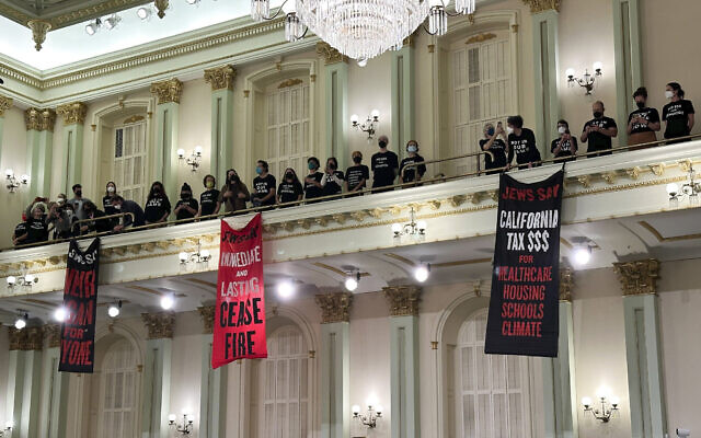 Protesters calling for a ceasefire in the Israel-Hamas war stand and sing in the Assembly chamber of the State Capitol in Sacramento, Calif., Wednesday, Jan. 3, 2024. The Assembly adjourned shortly after the protest began. (AP/Adam Beam) Protesters calling for a ceasefire in the Israel-Hamas war stand and sing in the Assembly chamber of the State Capitol in Sacramento, Calif., Wednesday, Jan. 3, 2024. The Assembly adjourned shortly after the protest began. (AP/Adam Beam)