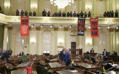 Assembly members Heath Flora, left, and Josh Lowenthal, right, leave the Assembly chambers as pro-Palestinian, anti-Israel protesters calling for a ceasefire in Gaza disrupt the first day of the California legislative session in Sacramento, California, January 3, 2024. (Rich Pedroncelli/AP)