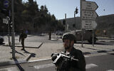 Israeli soldiers stand guard next to the scene of a Palestinian shooting attack, near Wadi al-Haramiya, West Bank, January 7, 2024. (AP Photo/Leo Correa)
