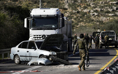 Israeli security forces examine the scene of a Palestinian shooting attack, near Wadi al-Haramiya, West Bank, January 7, 2024. (AP Photo/Leo Correa)