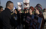 Relatives and friends of hostages held in the Gaza Strip by the Hamas terrorist group gather on the road near the Kerem Shalom border crossing between Israel and Gaza, in southern Israel, Tuesday, January 9, 2024. (AP Photo/Leo Correa)