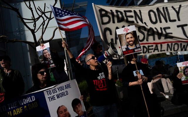 Families and supporters of Israeli hostages held by Hamas terrorists in Gaza hold signs and photos of their loved ones at a protest calling for their return, outside a meeting between US Secretary of State Antony Blinken and President Isaac Herzog, in Tel Aviv, January 9, 2024. (AP/Oded Balilty)