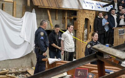 New York police officers arrest a Hasidic Jewish student after he was removed from a breach in the wall of the synagogue that led to a tunnel dug by students at Chabad-Lubavitch headquarters, January 8, 2024, in New York. (Bruce Schaff via AP)