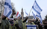Protesters wave Israeli flags and hold photos of the hostages kidnapped during the murderous October 7 Hamas attack on Israel, during a demonstration outside the International Court of Justice in The Hague, Netherlands, January 11, 2024. (AP Photo/Patrick Post)