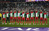 The Palestinian team stands for its national anthem ahead of the Asian Cup Group C soccer match between Iran and Palestine at the Education City Stadium in Al Rayyan, Qatar, January 14, 2024. (AP Photo/Aijaz Rahi)