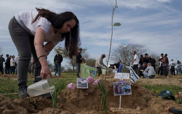 Ela Bahat pours water over the place she and her husband planted a tree and tulips in memory of their 30-year-old son Dror, who was murdered on Oct. 7 in a cross-border attack by Hamas terrorists at the Nova music festival in Re'im, southern Israel, Sunday, Jan. 21, 2024, during an event where friends and relatives planted trees in memory of their loved ones. (AP Photo/Leo Correa) Ela Bahat pours water over the place she and her husband planted a tree and tulips in memory of their 30-year-old son Dror, who was murdered on Oct. 7 in a cross-border attack by Hamas terrorists at the Nova music festival in Re'im, southern Israel, Sunday, Jan. 21, 2024, during an event where friends and relatives planted trees in memory of their loved ones. (AP Photo/Leo Correa)