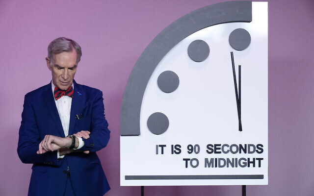 Science educator Bill Nye, looks at his watch next to the 'Doomsday Clock,' shortly before the Bulletin of the Atomic Scientists announces the latest decision on the 'Doomsday Clock' minute hand, Tuesday, Jan. 23, 2024, at the National Press Club Broadcast Center, in Washington, DC. (AP Photo/Jacquelyn Martin) Science educator Bill Nye, looks at his watch next to the 'Doomsday Clock,' shortly before the Bulletin of the Atomic Scientists announces the latest decision on the 'Doomsday Clock' minute hand, Tuesday, Jan. 23, 2024, at the National Press Club Broadcast Center, in Washington, DC. (AP Photo/Jacquelyn Martin)