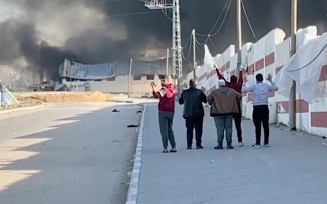 This image made from ITV News video shows a group of five men walking down a street west of the southern city of Khan Younis in Gaza while they hold their hands in the air and one waves a white flag. (ITV News via AP) This image made from ITV News video shows a group of five men walking down a street west of the southern city of Khan Younis in Gaza while they hold their hands in the air and one waves a white flag. (ITV News via AP)