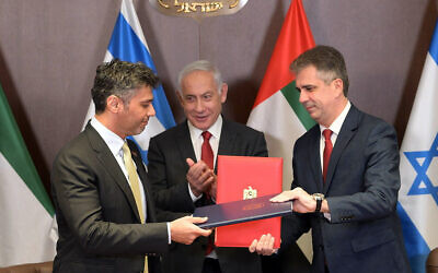 Prime Minister Benjamin Netanyahu, center, applauds as Foreign Minister Eli Cohen, right, and UAE Ambassador to Israel Mohamed al-Khaja, left, exchange signed copies of the customs agreement between the countries, March 26, 2023. (Amos Ben Gershom/GPO)