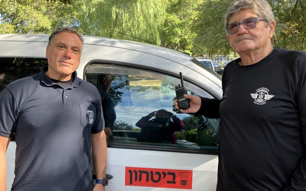 Shlomo Brand, right, with Yishai Windmiller by their delivery vehicle, December 2023. (Diana Bletter)