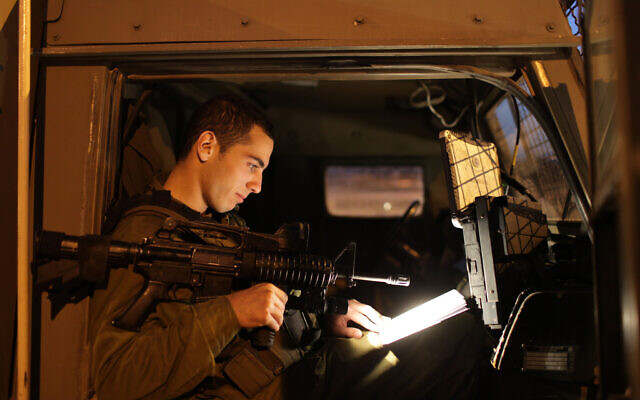 Illustrative: An Israeli soldier reads a book in a military jeep on November 30, 2009. (Nati Shohat/Flash90/File) Illustrative: An Israeli soldier reads a book in a military jeep on November 30, 2009. (Nati Shohat/Flash90/File)