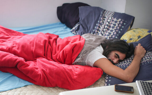 Illustrative: A young Israeli man sleeping in his bed, December 1, 2014. (Maxim Dinshtein/Flash90)