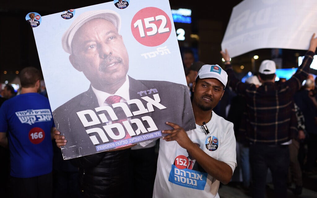 A Likud center member holds up a placard of Avraham Neguise in the primaries for the Likud party at the Tel Aviv Likud polling station on February 5, 2019. (Gili Yaari/Flash90)