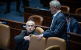 Then-Minister Benny Gantz, right, shakes hands with Prime Minister Benjamin Netanyahu in the Knesset in Jerusalem, December 25, 2023. (Yonatan Sindel/Flash90)