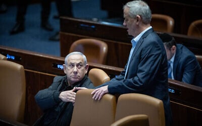 Then-Minister Benny Gantz, right, shakes hands with Prime Minister Benjamin Netanyahu in the Knesset in Jerusalem, December 25, 2023. (Yonatan Sindel/Flash90)