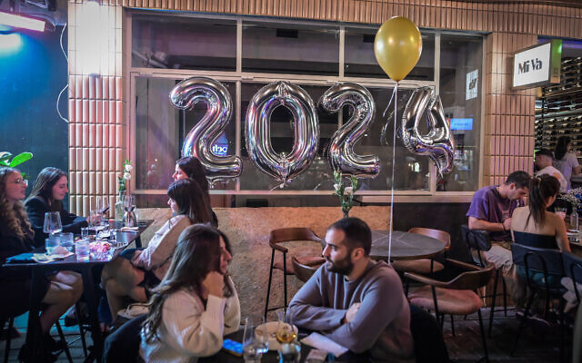 Israelis celebrating New Year's Eve in Tel Aviv, December 31, 2023. (Photo by Avshalom Sassoni/Flash90) Israelis celebrating New Year's Eve in Tel Aviv, December 31, 2023. (Photo by Avshalom Sassoni/Flash90)