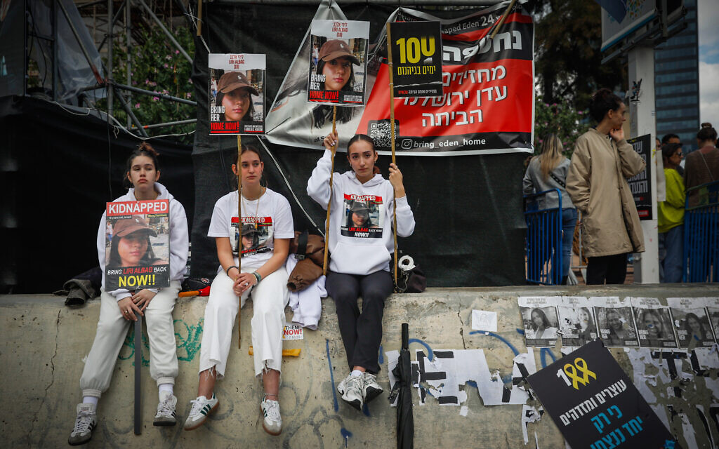 Three girls hold signs calling for the return of hostage Liri Albag from Gaza as people attend 24-hour rally marking 100 days since the October 7 Hamas onslaught, at Hostage Square in Tel Aviv, on January 14, 2024. (Miriam Alster/Flash90)