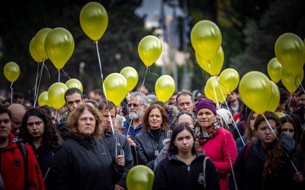 People holding yellow balloons at a rally for hostages, marking 100 days since the start of the war between Israel and Hamas, at the Hebrew University of Jerusalem on January 14, 2024. (Yonatan Sindel/Flash90)