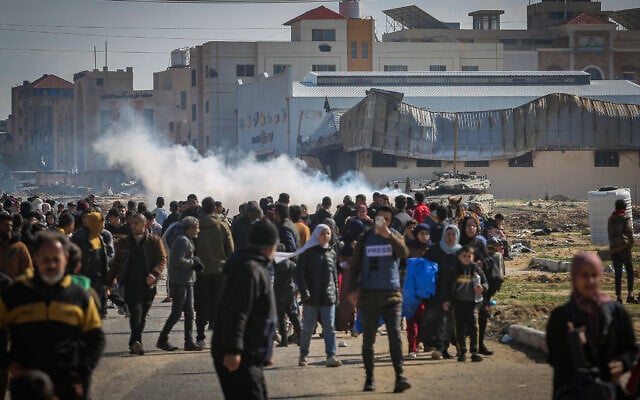 IDF tanks secure the area while Palestinians fleeing from combat areas in Khan Younis to Rafah, in the southern Gaza Strip, January 26, 2024. (Atia Mohammed/Flash90)