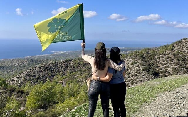Bereaved Israeli parents waving a Golani brigade flag in Cyprus, in an undated courtesy photo. (Nir Davidzon/Secret Forest)