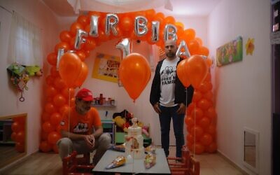 Shiri Bibas' cousins Jimmy Miller (left) and Yosi Shnadier hold a somber celebration on January 16, 2024 at Kibbutz Nir Oz ahead of the first birthday on January 18 of Kfir Bibas, the youngest hostage in Gaza of terror group Hamas. (Courtesy of the Hostages and Missing Families Forum)