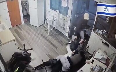Screen capture from video showing two Israeli security guards struggling for control of a rifle seized by a terrorist during a stabbing attack, January 1, Mishor Adumim. (X. Used in accordance with Clause 27a of the Copyright Law)