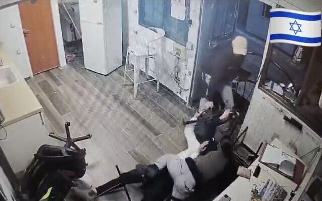Screen capture from video showing two Israeli security guards struggling for control of a rifle seized by a terrorist during a stabbing attack, January 1, Mishor Adumim. (X. Used in accordance with Clause 27a of the Copyright Law) Screen capture from video showing two Israeli security guards struggling for control of a rifle seized by a terrorist during a stabbing attack, January 1, Mishor Adumim. (X. Used in accordance with Clause 27a of the Copyright Law)