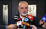 This handout picture provided by the Iranian foreign ministry on December 20, 2023, shows Qatar-based Hamas politburo leader Ismail Haniyeh speaking to journalists as he welcomes the Iranian foreign minister (not in the picture), in Doha. (Iranian Foreign Ministry / AFP)