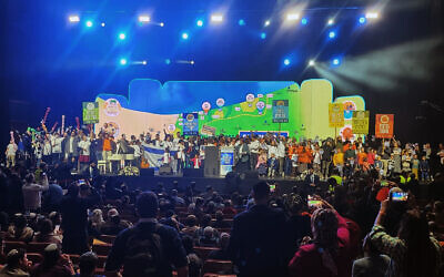 Settlement activists at a conference in Jerusalem to promote the construction of Jewish settlements in Gaza go up on stage in dedicated groups that seek to establish six new settlements in the coastal enclave, January 28, 2024. (Courtesy the Nachala Settlement Movement)