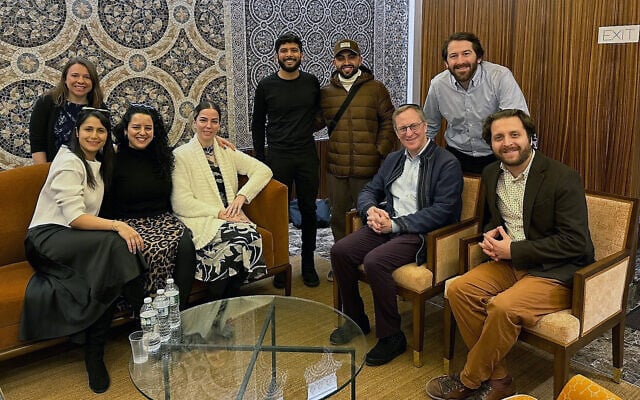 Members of a conversion program meeting in New York City on December 21, 2023. Jasamine Hodge is seated in the center in a white sweater, with her fiancé Adir standing to her left. Seated on the right are Rabbis Adam Mintz and Avram Mlotek. (Courtesy of Hodge via JTA)