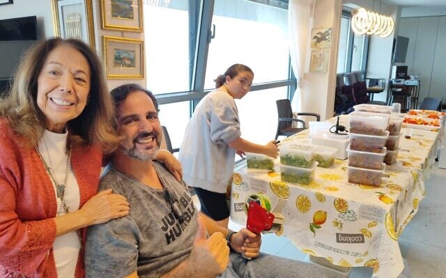 Shekoufeh 'Chicki' Elghanian, left, and volunteers at her Herzliya apartment, on December 28, 2023. (Gavriel Fiske/TOI)