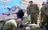 Prime Minister Benjamin Netanyahu, in black, plants a tree at a military base near Gaza on January 25, 2024. (Amos Ben Gershom / GPO)