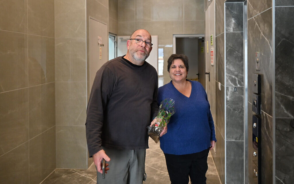 Maya Argov and Jonathan Dekel-Chen enter on January 3, 2024 an apartment building in Kiryat Gat where survivors of Kibbutz Nir Oz are staying. (Canaan Lidor/Times of Israel)