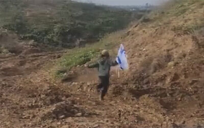 One of two young Israeli children who managed to slip under the Gaza border fence, heading toward the Strip while carrying an Israeli flag on January 25, 2024. (Screen grab used in accordance with Clause 27a of the Copyright Law)