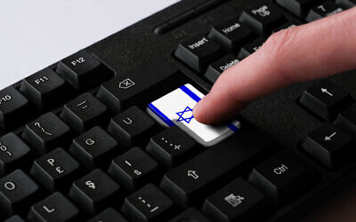 A person uses a keyboard featuring an Israeli flag (Hakan Gider/ iStock)