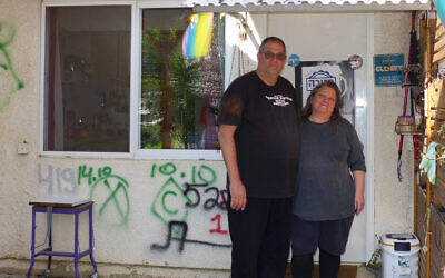 Shahar Schnorman (left) and Ayelet Cohen at the entrance to their home in Kibbutz Kfar Aza, with rescue forces' graffiti on the wall behind them, on January 25, 2024. (Canaan Lidor/Times of Israel) Shahar Schnorman (left) and Ayelet Cohen at the entrance to their home in Kibbutz Kfar Aza, with rescue forces' graffiti on the wall behind them, on January 25, 2024. (Canaan Lidor/Times of Israel)