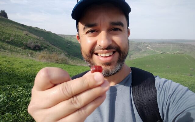 Erez Abrahamov with his discovery, in an undated photo released on Wednesday, February 7, 2024. (Erez Abrahamov/IAA)