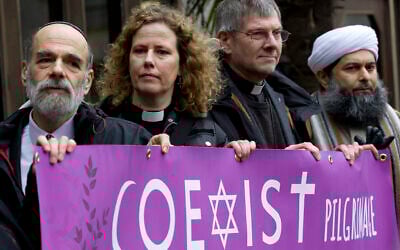 File: (Left to right) Rabbi Jonathan Wittenberg, Reverend Margaret Cave, the Dean of Coventry John Witcombe and the Assistant Secretary General of the Muslim Association of Great Britain, Ibrahim Mogra pose for photographers with a banner reading 'Coexist pilgrimage' outside Regents Park Mosque before setting off for an interreligious march for peace to St Thomas' Hospital in London on February 19, 2015. (Photo by Justin TALLIS / AFP)