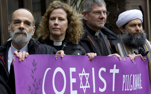 File: (Left to right) Rabbi Jonathan Wittenberg, Reverend Margaret Cave, the Dean of Coventry John Witcombe and the Assistant Secretary General of the Muslim Association of Great Britain, Ibrahim Mogra pose for photographers with a banner reading 'Coexist pilgrimage' outside Regents Park Mosque before setting off for an interreligious march for peace to St Thomas' Hospital in London on February 19, 2015. (Photo by Justin TALLIS / AFP) File: (Left to right) Rabbi Jonathan Wittenberg, Reverend Margaret Cave, the Dean of Coventry John Witcombe and the Assistant Secretary General of the Muslim Association of Great Britain, Ibrahim Mogra pose for photographers with a banner reading 'Coexist pilgrimage' outside Regents Park Mosque before setting off for an interreligious march for peace to St Thomas' Hospital in London on February 19, 2015. (Photo by Justin TALLIS / AFP)