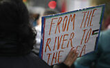 Illustrative - A demonstrator displays a placard with 'From the river to the sea' during a rally in solidarity with Palestinians at Oranienplatz Square in Berlin's Kreuzberg district, Germany, on November 11, 2023. (Tobias Schwarz/ AFP)