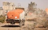 Vehicles transporting humanitarian aid drive along the Salaheddin road in the Zeitoun district on the southern outskirts of Gaza City on November 26, 2023. (Mahmud Hams/AFP)