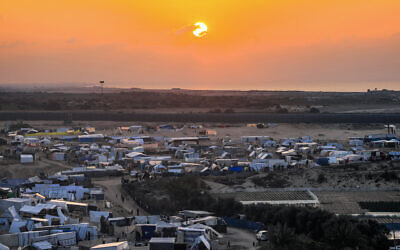 The sun sets over Egypt across the border from the tent camps of displaced Palestinians in Rafah in the southern Gaza Strip on December 31, 2023. (Photo by AFP)