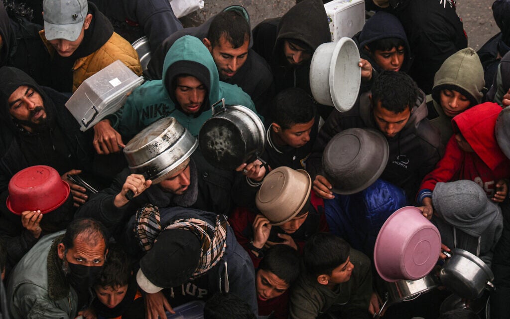 Palestinians receive food rations at a donation point at a camp for internally displaced people in Rafah in the southern Gaza Strip on February 2, 2024 (SAID KHATIB / AFP)