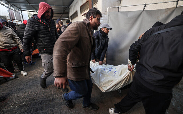 People carry the body of a person said to have been killed in an Israeli strike, at the Najjar hospital in Rafah in the southern Gaza Strip on February 3, 2024. (Said Khatib/AFP) People carry the body of a person said to have been killed in an Israeli strike, at the Najjar hospital in Rafah in the southern Gaza Strip on February 3, 2024. (Said Khatib/AFP)