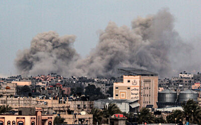 A picture taken from Rafah in the southern Gaza Strip shows smoke rising over buildings in Khan Younis in the distance, following Israeli bombardment on February 5, 2024 as fighting continues between Israel and Hamas. (SAID KHATIB / AFP)