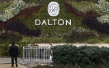 A man walks next to a Dalton Winery sign in the northern moshav of Dalton near the Lebanon border on January 29, 2024. (jalaa marey / AFP)