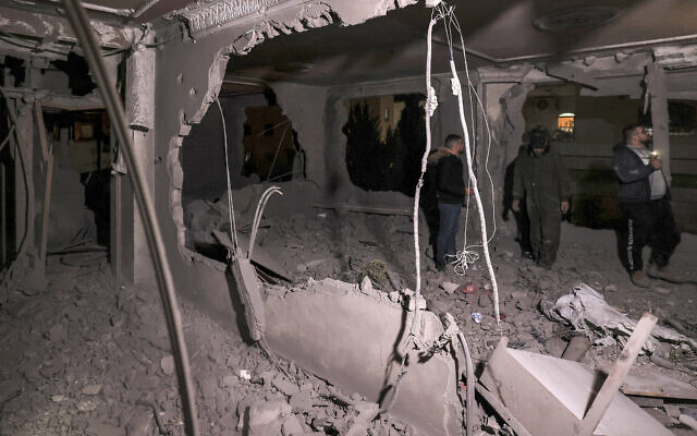 People inspect damage after the controlled demolition by Israeli forces of the apartment of Hassan Qafisha, one of three Hamas members who carried out a deadly attack on an Israeli checkpoint in the West Bank near Jerusalem on November 16, 2023, in the West Bank city of Hebron early on February 8, 2024. (HAZEM BADER / AFP)