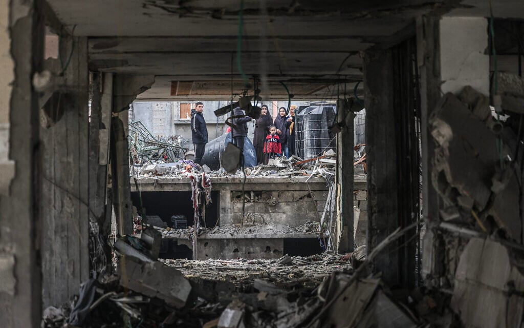 People assess the damage caused by Israeli bombardment in Rafah in the southern Gaza Strip on February 9, 2024, (Mahmud Hams/AFP)