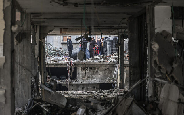 People assess the damage caused by Israeli bombardment in Rafah in the southern Gaza Strip on February 9, 2024, (Mahmud Hams/AFP)